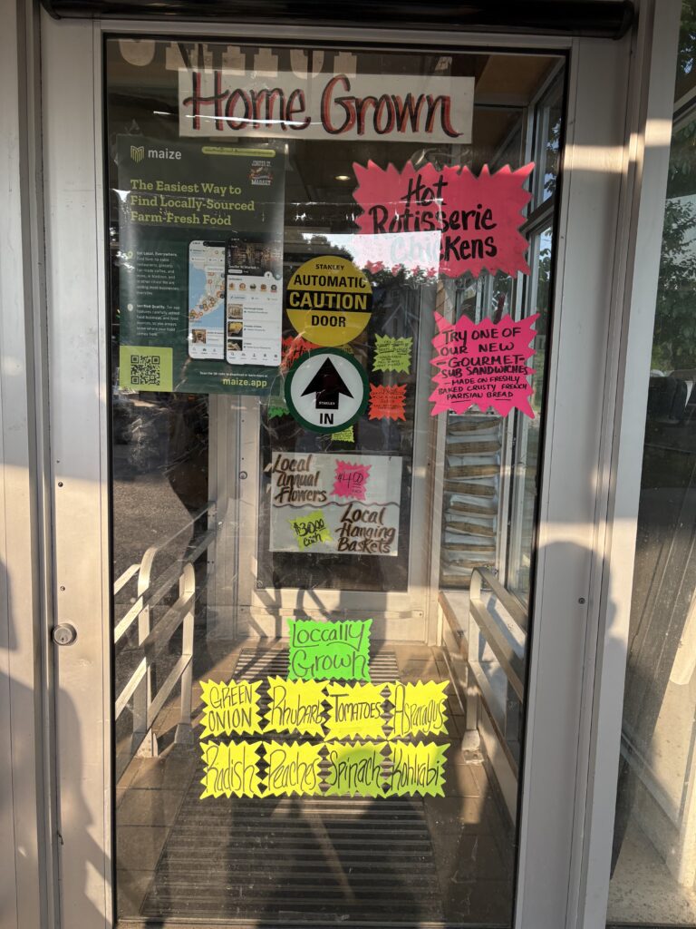 The door to a grocery store with brightly handmade signs