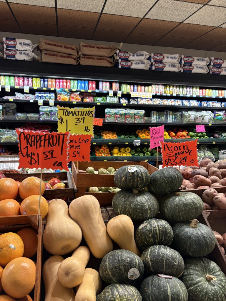 A grocery store produce aisle with brightly colored handmade signs