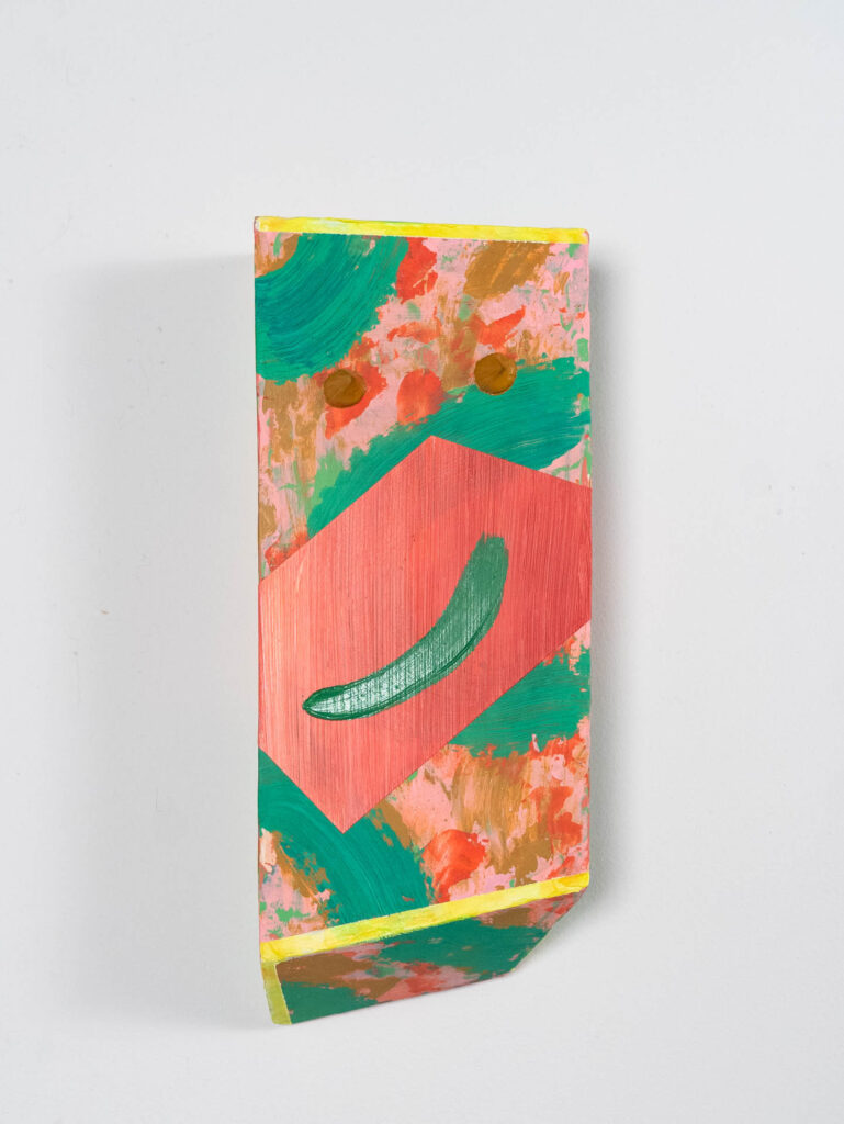 An abstract wall mounted sculpture of pink and green