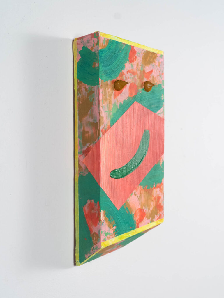 An abstract wall mounted sculpture of pink and green
